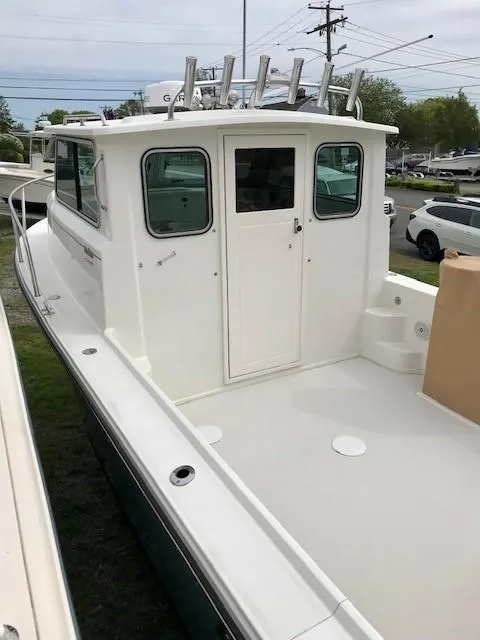 Slide: The Image of 2017 Parker 2520 XL Sport Cabin boat, white exterior, docked outdoors. - 5