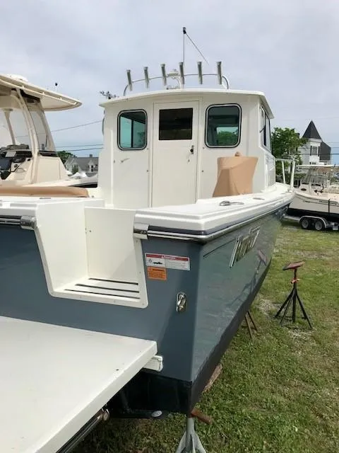 Slide: The Image of 2017 Parker 2520 XL Sport Cabin boat displayed on grass. - 6