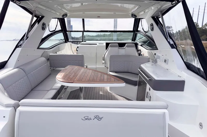 Slide: The Image of 2022 Sea Ray Sundancer 320 interior with elegant seating and wooden table. - 12