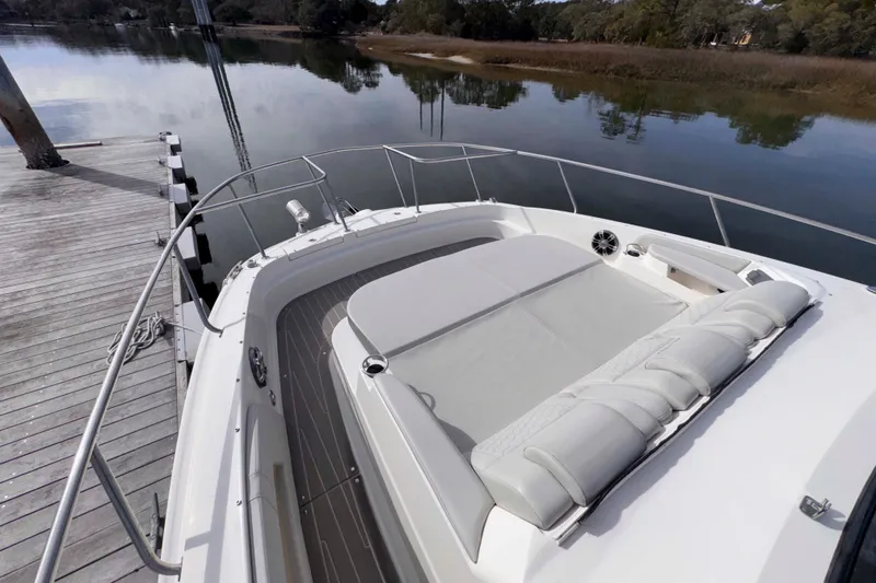 Slide: The Image of 2022 Sea Ray Sundancer 320 boat with spacious deck and luxurious seating by the dock. - 13