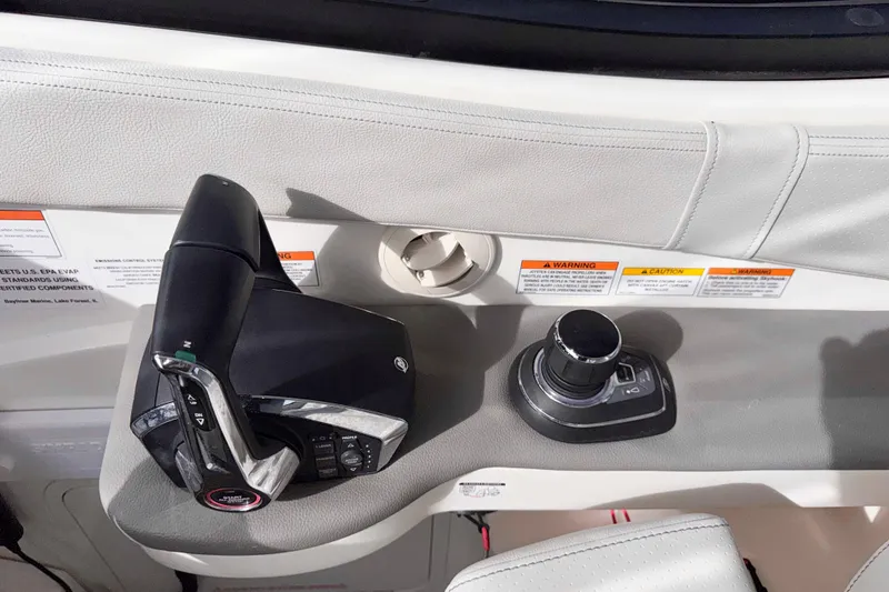 Slide: The Image of 2022 Sea Ray Sundancer 320 helm controls with joystick and throttle levers. - 19