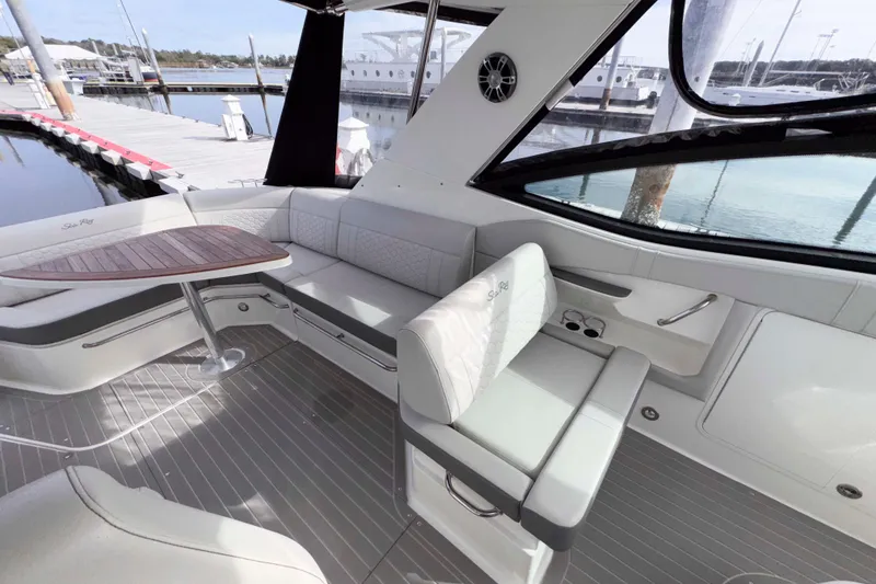Slide: The Image of 2022 Sea Ray Sundancer 320 interior with elegant seating and wooden table at marina. - 21
