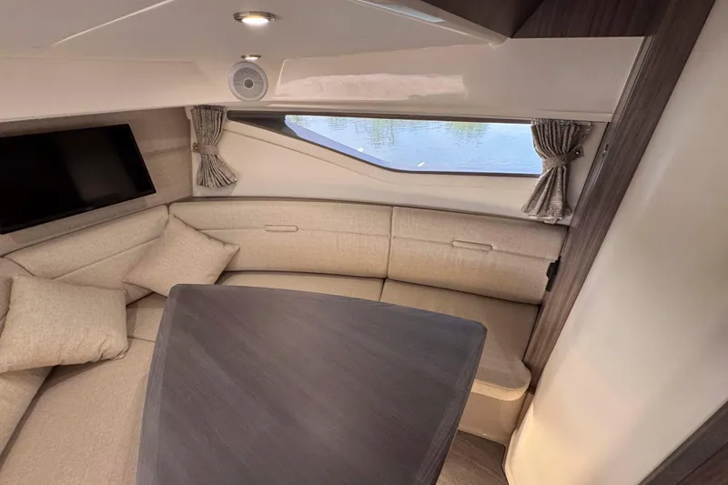 Slide: The Image of Interior of 2022 Sea Ray Sundancer 320 yacht with cozy seating and window view. - 33