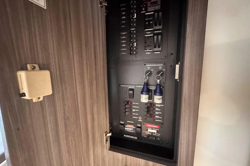 Slide: The Image of Electrical panel inside 2022 Sea Ray Sundancer 320 boat, featuring switches and keys. - 36