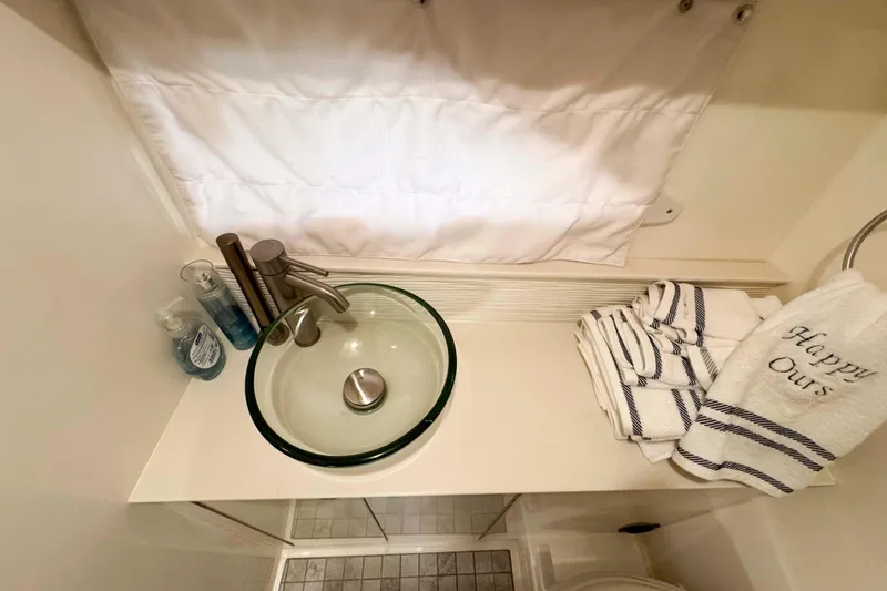Slide: The Image of Elegant bathroom sink area on 2022 Sea Ray Sundancer 320 yacht with towels and toiletries. - 37