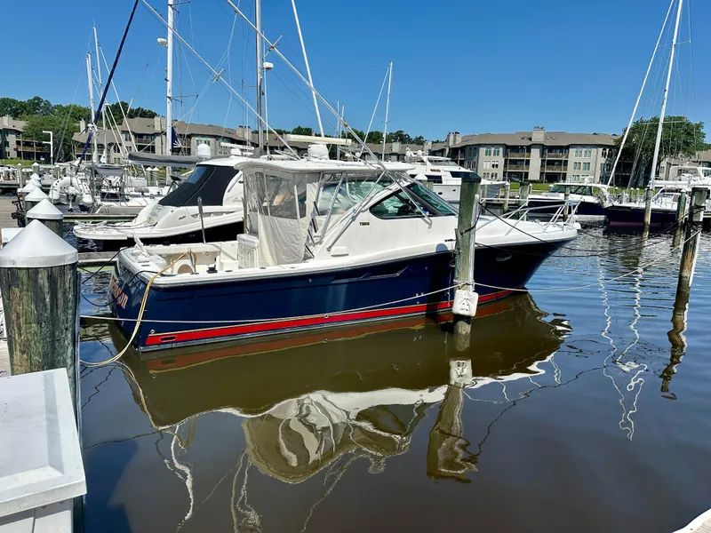 Slide: The Image of 2005 Tiara Yachts 3600 Open docked at marina, clear blue sky, calm water reflections. - 3