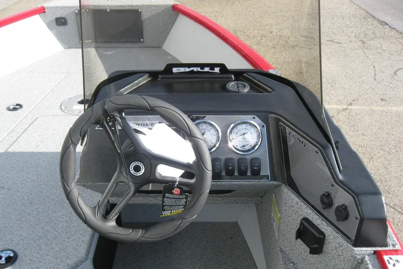 Slide: The Image of 2024 Lund 1775 Adventure SS boat interior with steering wheel and control panel. - 12