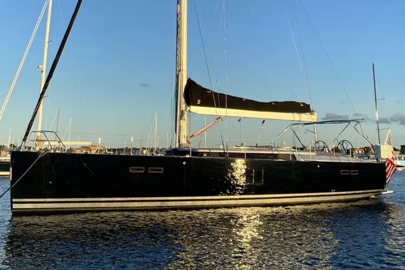 The Image of 2010 Hanse 545 yacht on calm water at sunset, featuring sleek black hull. - 0