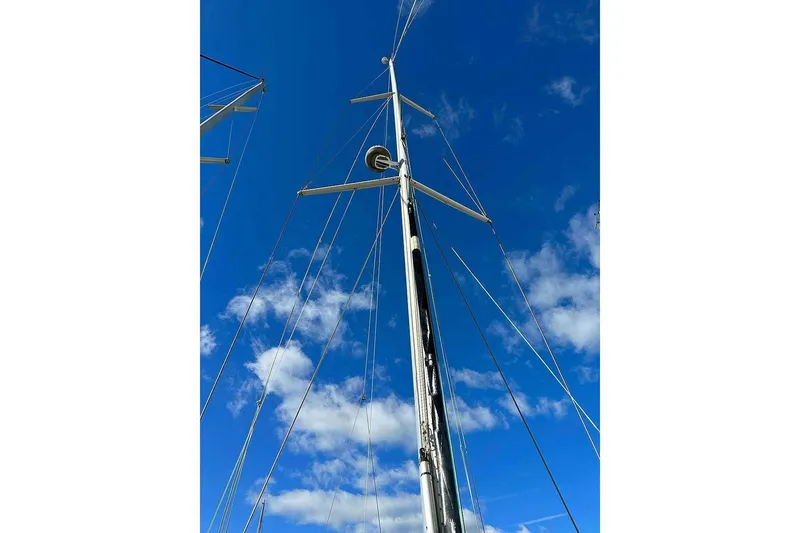 Slide: The Image of Mast of 2010 Hanse 545 sailboat against a clear blue sky with clouds. - 10