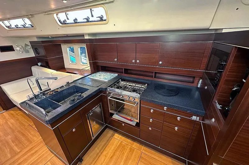 Slide: The Image of Luxurious 2010 Hanse 545 yacht interior kitchen with modern appliances and elegant wood cabinetry. - 14