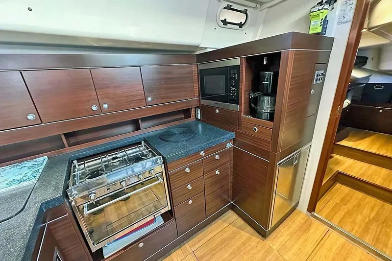 Slide: The Image of Luxurious 2010 Hanse 545 yacht kitchen with modern appliances and sleek wooden cabinetry. - 15