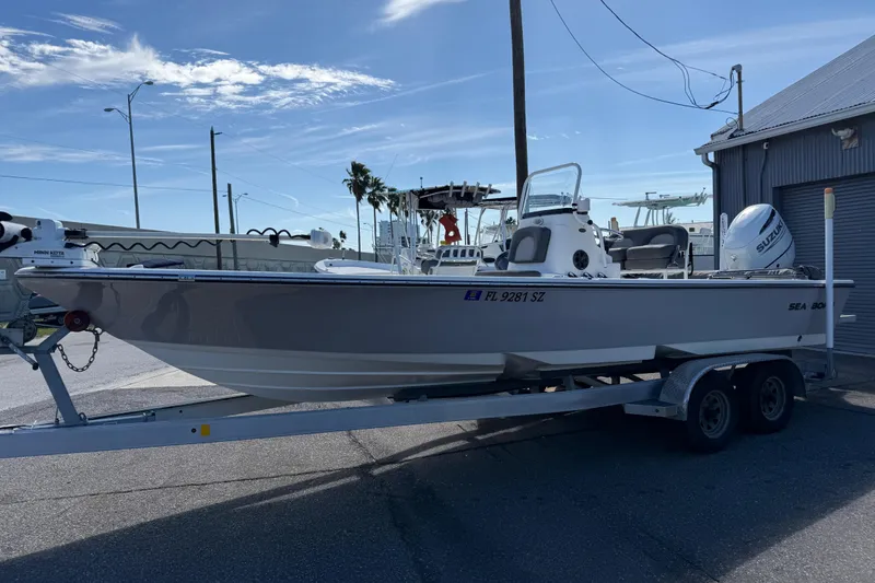 Slide: The Image of 2021 Sea Born FX24 Bay boat on trailer, parked outdoors under clear sky. - 4