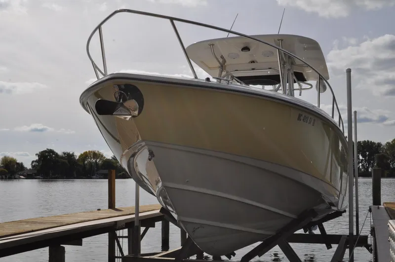 Slide: The Image of 2006 Boston Whaler 320 Outrage on a boat lift by the lake. - 2