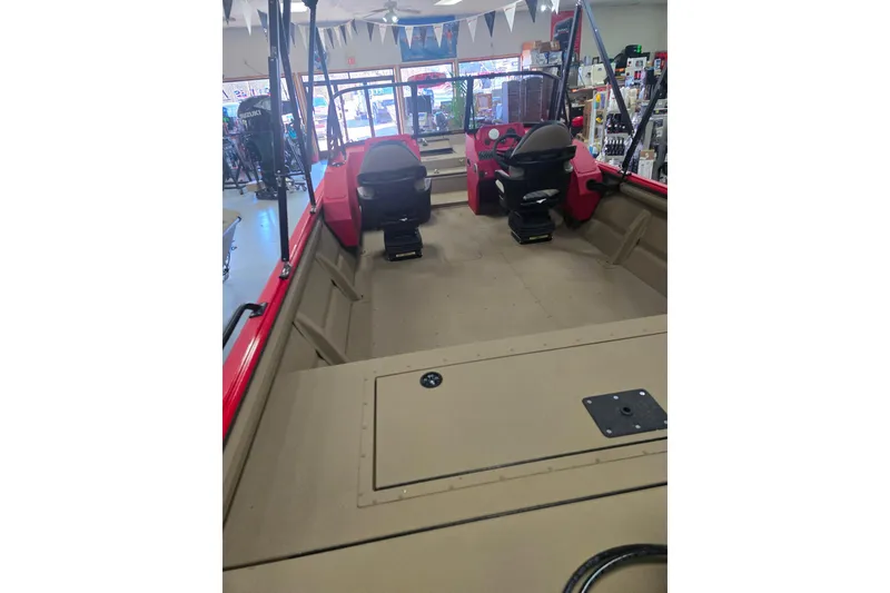 Slide: The Image of Captain's seat in 2026 SeaArk Protege 240 boat, featuring a red dashboard and steering wheel. - 5