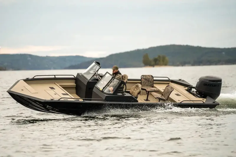 Slide: The Image of 2026 SeaArk Protege 240 boat interior with red accents and seating in a showroom. - 6