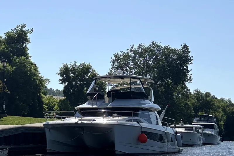 Slide: The Image of Aquila 44 Yacht 2018 docked on a sunny day with trees in the background. - 24