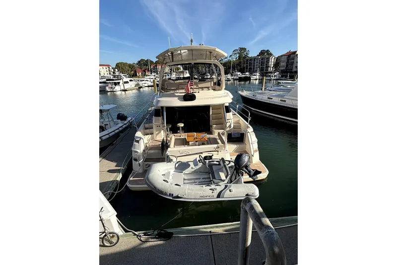 Slide: The Image of 2018 Aquila 44 Yacht docked in marina with inflatable boat attached. - 28