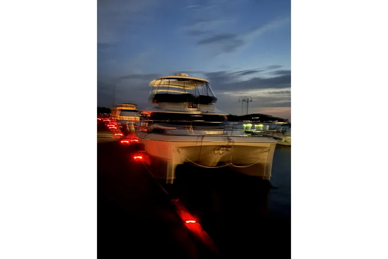 Slide: The Image of Aquila 44 Yacht 2018 docked at night with glowing lights and dark sky. - 30