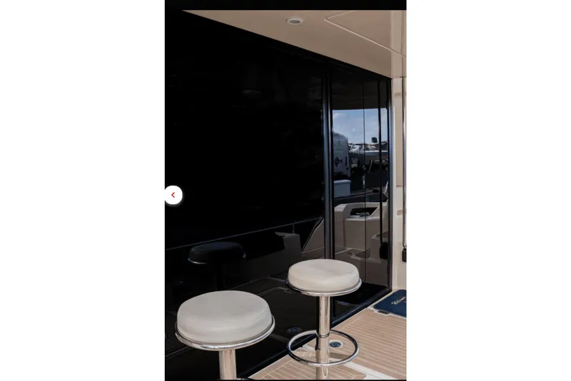 Slide: The Image of 2018 Aquila 44 Yacht interior with bar stools and sleek black paneling. - 5
