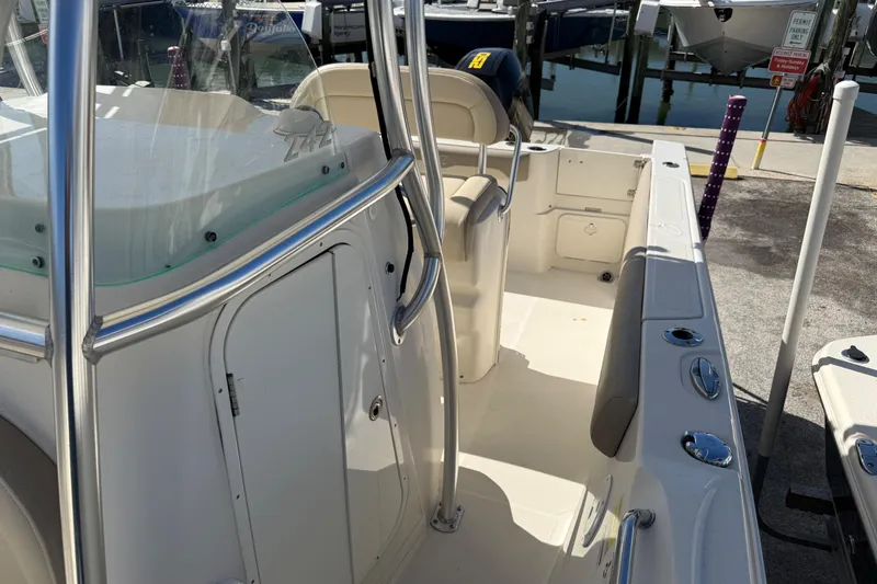Slide: The Image of 2021 Sailfish 242 CC boat interior with seating and console, docked at marina. - 11
