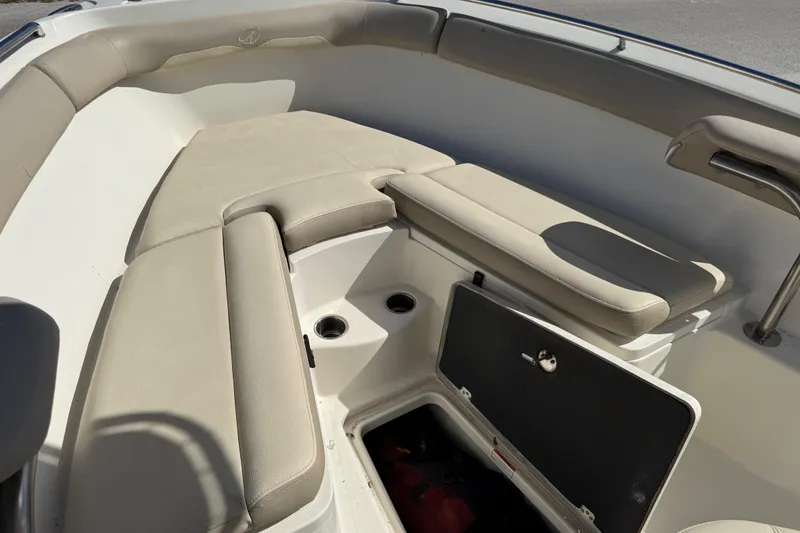 Slide: The Image of 2021 Sailfish 242 CC boat interior with beige cushioned seating and storage compartment. - 13