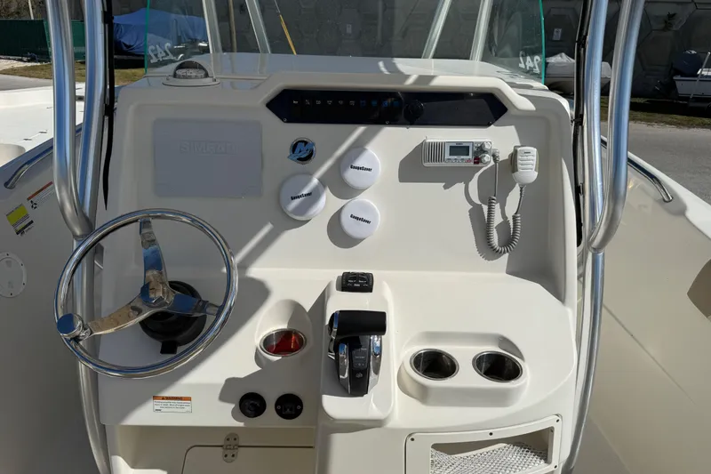 Slide: The Image of 2021 Sailfish 242 CC boat console with steering wheel, controls, and communication equipment. - 8