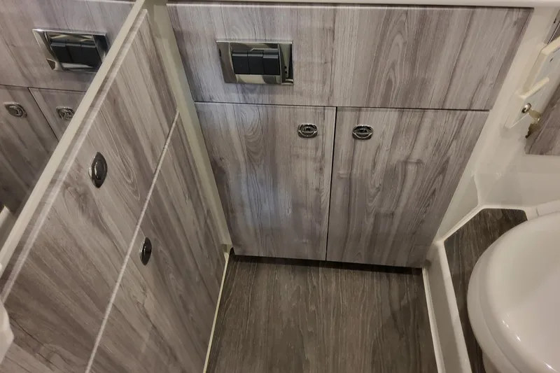 Slide: The Image of 2026 Formula 360 Crossover Bowrider OB bathroom with wood finish cabinets and modern fixtures. - 106