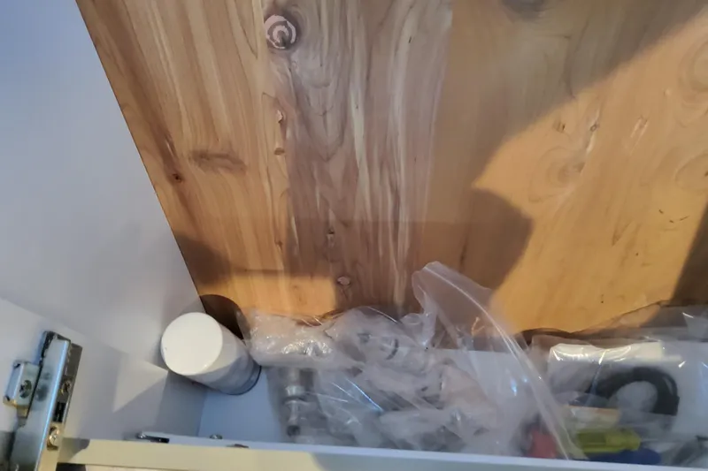 Slide: The Image of Cabinet interior with wooden panel, plastic bags, and a white container. Formula 360 Crossover Bowrider OB 2026. - 94