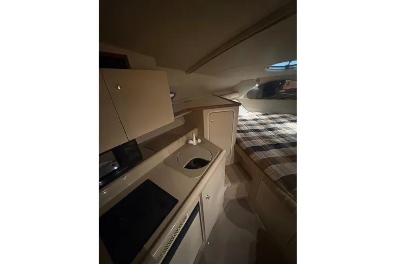 Slide: The Image of Interior of 2000 Cruisers Yachts 2870 Express, featuring kitchenette and cozy sleeping area. - 11