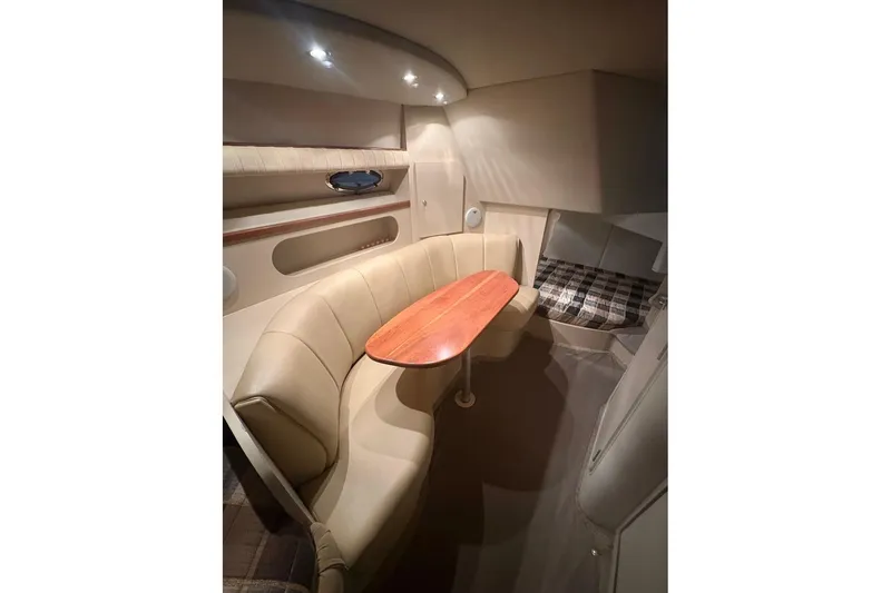 Slide: The Image of Interior of 2000 Cruisers Yachts 2870 Express with cozy seating and wooden table. - 12