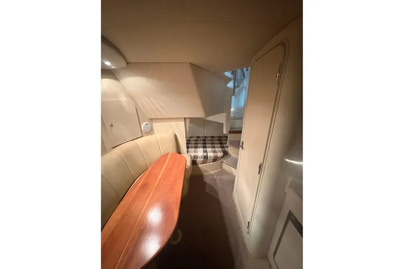 Slide: The Image of Interior of 2000 Cruisers Yachts 2870 Express, featuring cozy seating and a compact cabin space. - 13