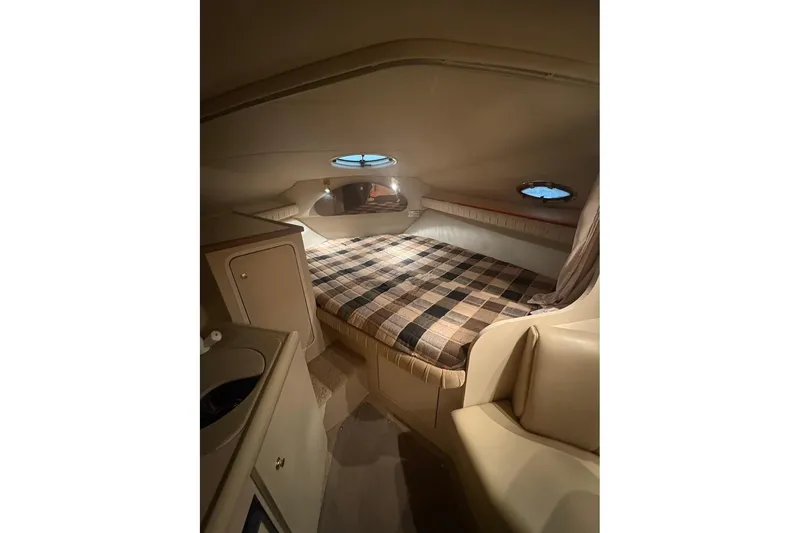 Slide: The Image of Cozy cabin interior of 2000 Cruisers Yachts 2870 Express with plaid bedding. - 14