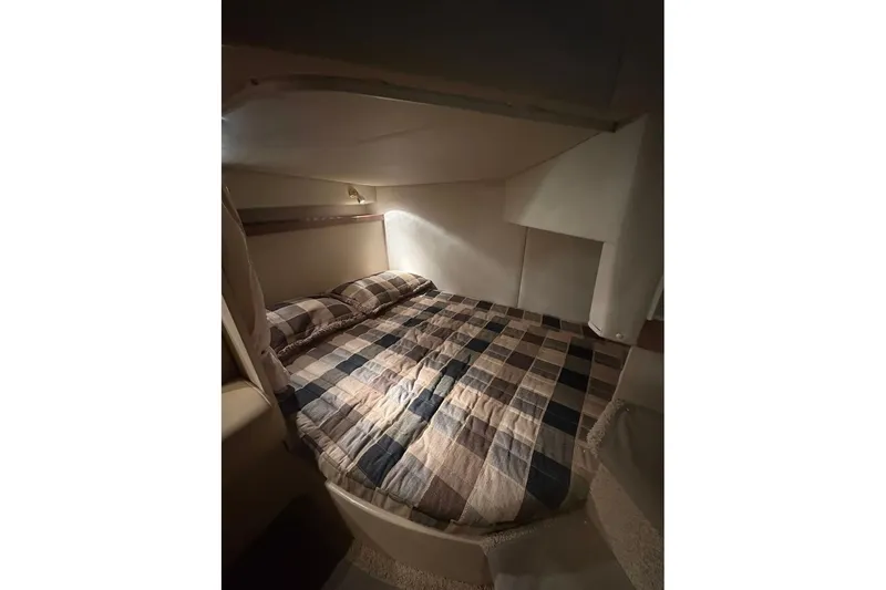 Slide: The Image of Cozy cabin interior of 2000 Cruisers Yachts 2870 Express with plaid bedding. - 15