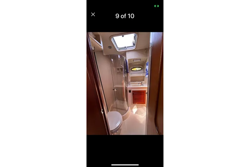 Slide: The Image of 1987 Tiara 3600 yacht bathroom interior with toilet, sink, and porthole window. - 14