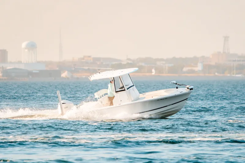 Slide: The Image of 2021 Regulator 24XO boat cruising on water with city skyline. - 5