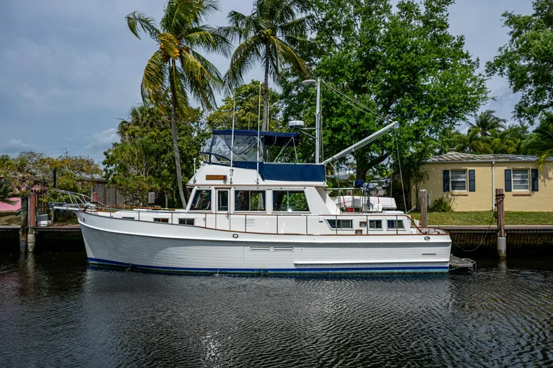 The Image of 1990 Grand Banks 46 Classic yacht docked by palm trees. - 0
