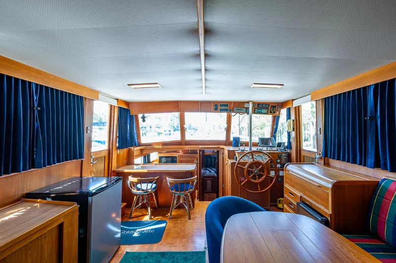 Slide: The Image of Interior of 1990 Grand Banks 46 Classic yacht with wooden furnishings and blue curtains. - 20