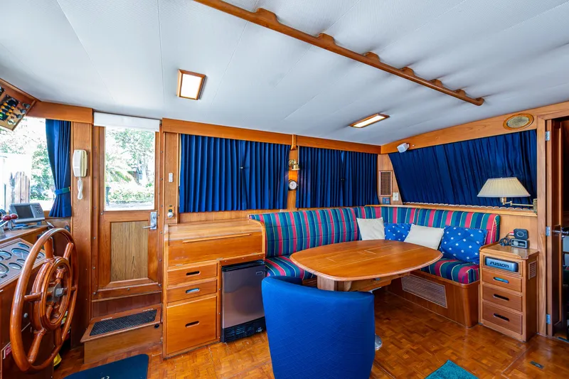 Slide: The Image of Interior of 1990 Grand Banks 46 Classic yacht with wood finish and blue-striped seating. - 21