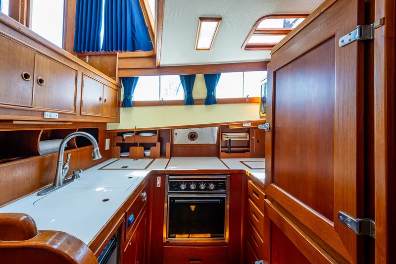 Slide: The Image of Interior of 1990 Grand Banks 46 Classic yacht, featuring a well-equipped wooden kitchen. - 29