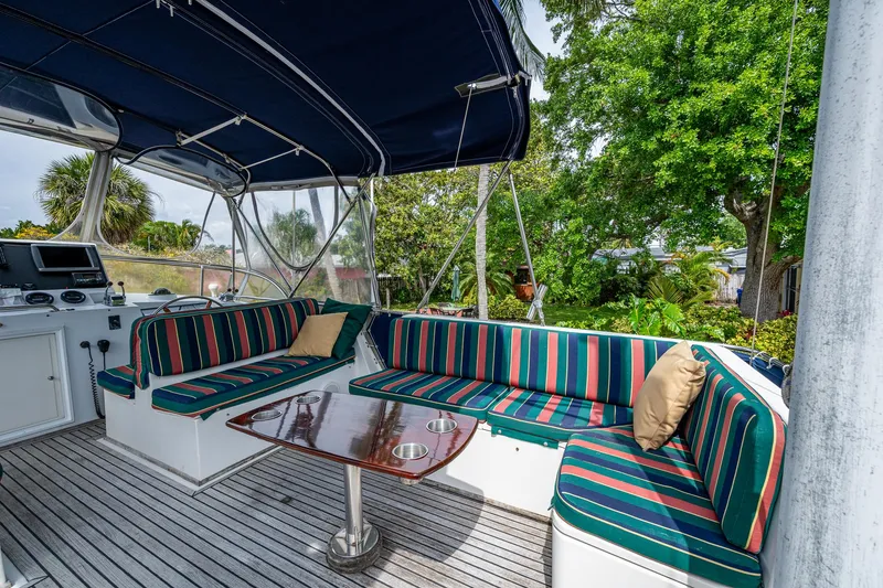 Slide: The Image of Grand Banks 46 Classic 1990 yacht deck with striped seating and wooden table. - 3