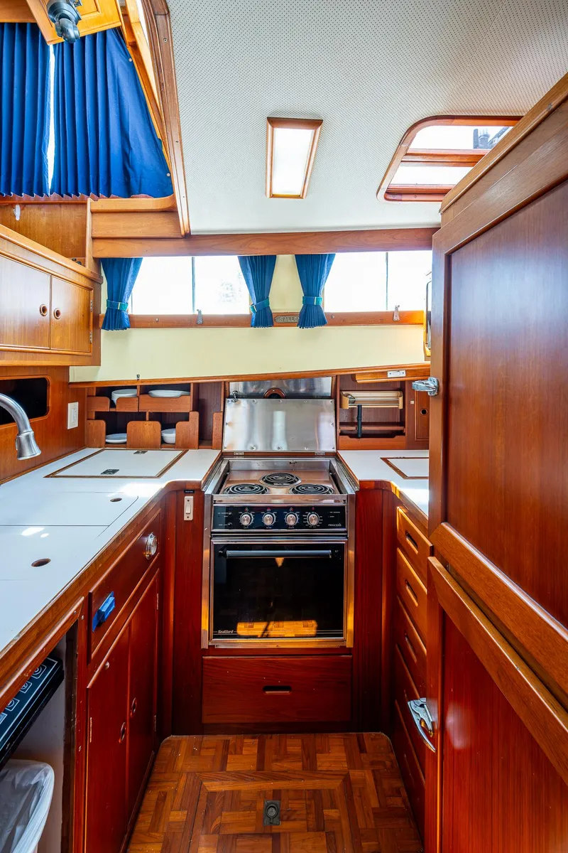 Slide: The Image of Interior of 1990 Grand Banks 46 Classic yacht, featuring a well-equipped wooden kitchen. - 31