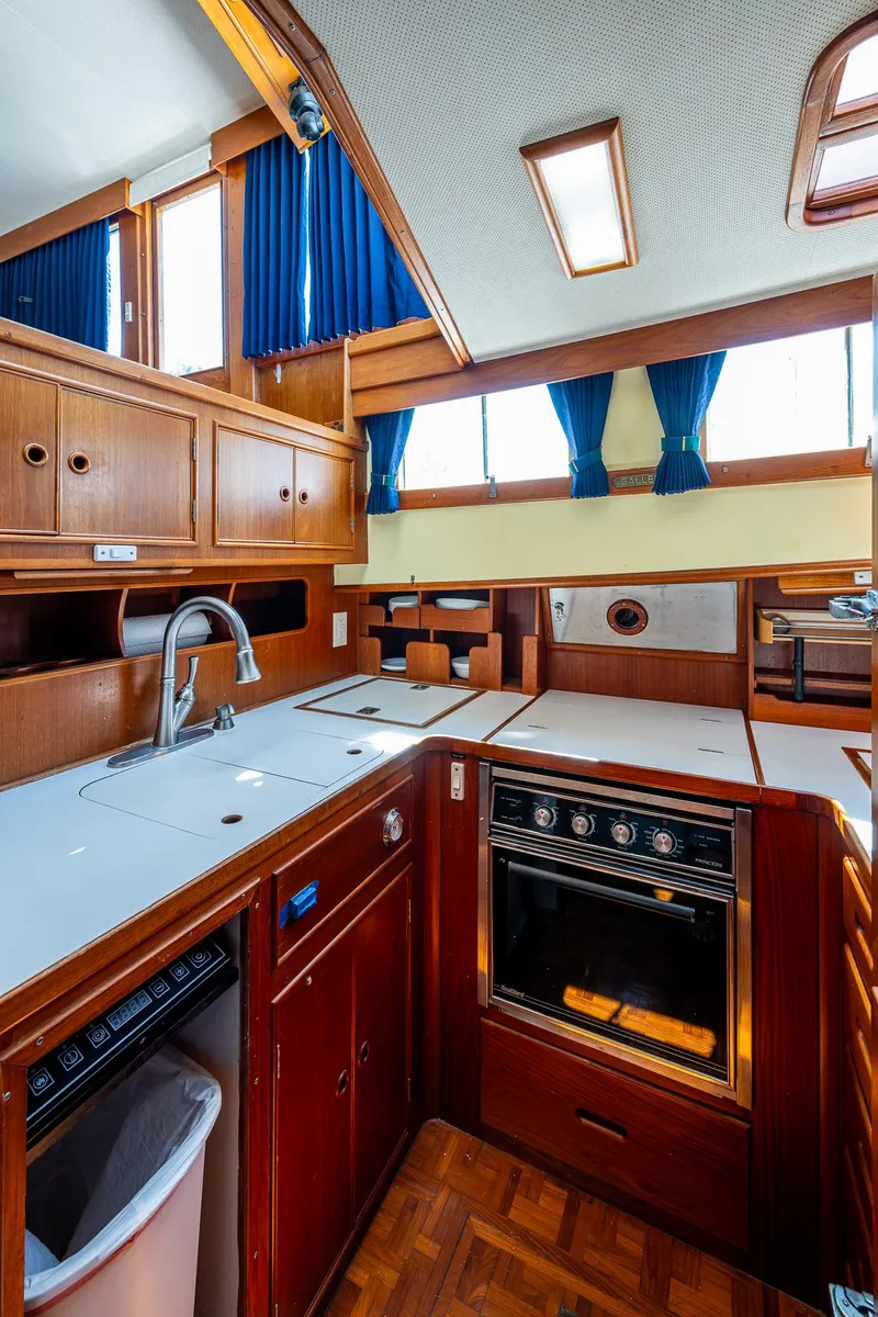 Slide: The Image of 1990 Grand Banks 46 Classic yacht kitchen with wood cabinetry and modern appliances. - 35