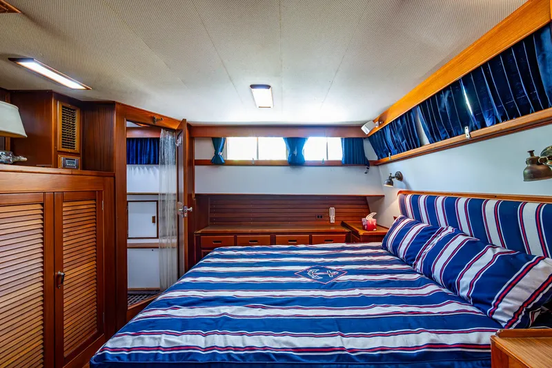 Slide: The Image of Luxurious bedroom interior of 1990 Grand Banks 46 Classic yacht with striped bedding. - 38