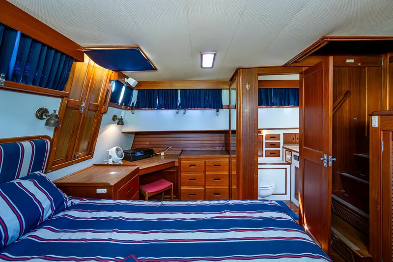 Slide: The Image of Grand Banks 46 Classic 1990 yacht interior with wood finish and striped bedding. - 39