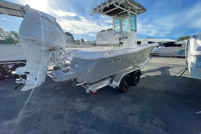Slide: The Image of 2026 Caymas 24 HB boat with Yamaha engine, parked on a trailer under a clear blue sky. - 3