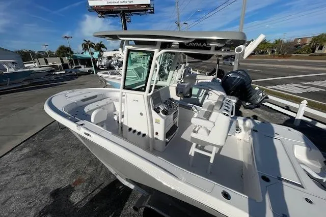Slide: The Image of 2026 Caymas 24 HB boat with sleek design, docked outdoors under clear blue sky. - 5