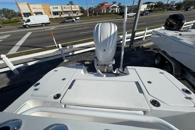 Slide: The Image of 2026 Caymas 24 HB boat with outboard motor, parked near a road. - 8