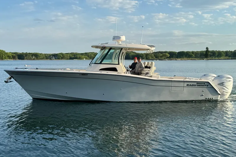 Slide: The Image of 2020 Grady-White Canyon 336 boat on calm water, featuring dual outboard engines. - 13