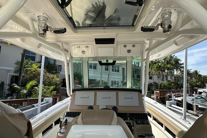 Slide: The Image of 2019 Sailfish 360 CC boat cockpit with Garmin displays and overhead storage. - 15