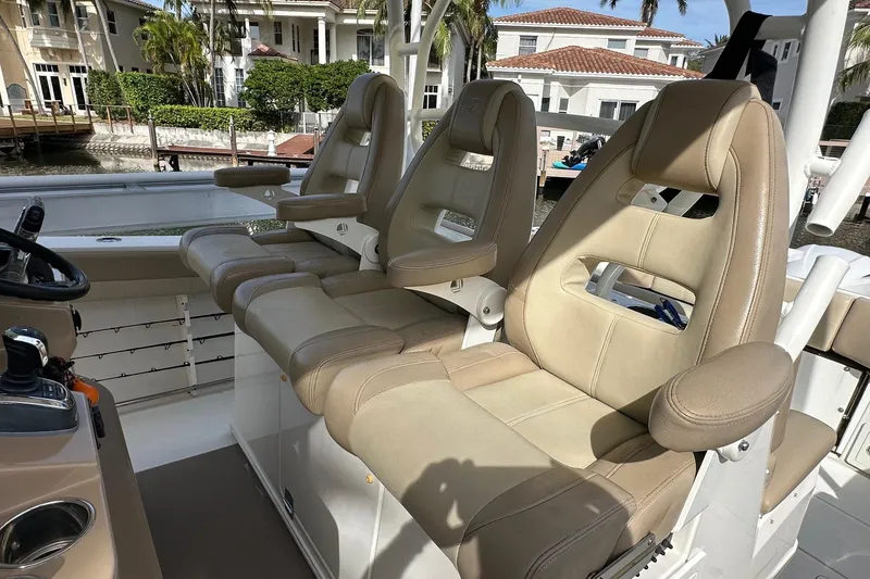 Slide: The Image of Luxurious seating on 2019 Sailfish 360 CC boat, featuring beige leather chairs and armrests. - 17